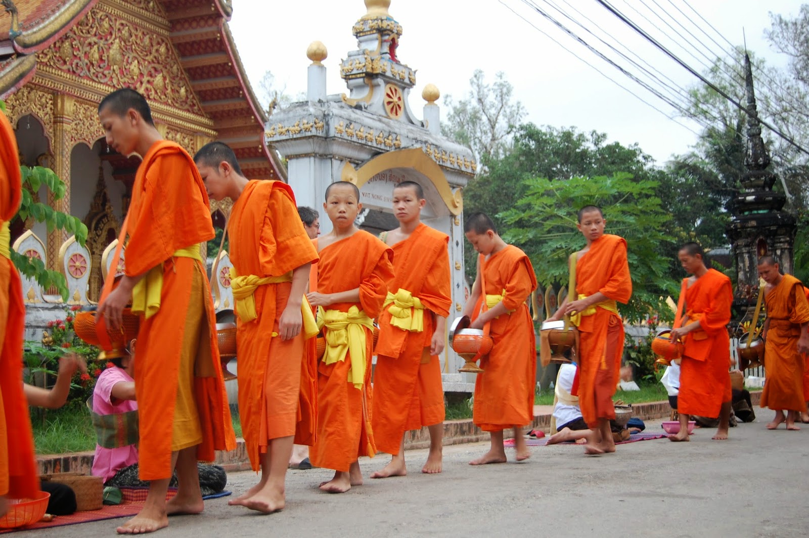 Monks receive food and flowers from local people