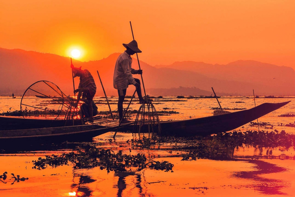 Fishermen maneuver their boats with only one leg in Inle Lake